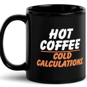 May include: Black ceramic coffee mug with a curved handle. The mug features the text "HOT COFFEE COLD CALCULATIONS" in white and orange lettering. The mug is designed for hot beverages.