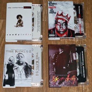 May include: Four cassette tapes with album art. The top left features "Ready to Die" with a baby image. The top right shows "Duets: The Final Chapter". The bottom left displays "The King & I". The bottom right shows "Life After Death".