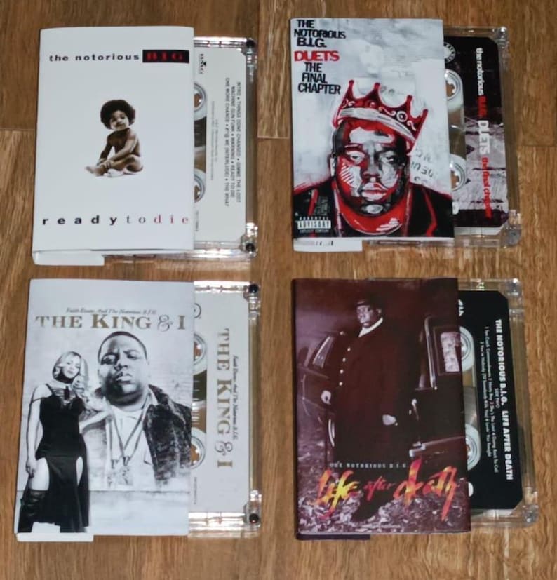 May include: Four cassette tapes with album art. The top left features "Ready to Die" with a baby image. The top right shows "Duets: The Final Chapter". The bottom left displays "The King & I". The bottom right shows "Life After Death".