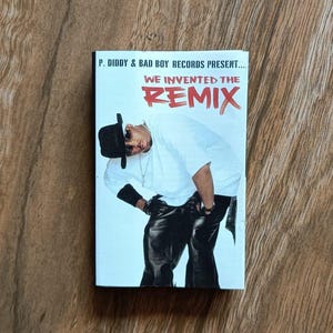 Peut inclure: Un boîtier de CD avec P. Diddy & Bad Boy Records. La couverture présente un homme en chemise blanche, pantalon en cuir noir et chapeau noir. Le texte sur le boîtier indique "WE INVENTED THE REMIX."
