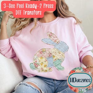 May include: A light pink sweatshirt featuring a patchwork bunny design with floral, gingham, and lace patterns. The text "3-Sec Peel Ready-2 Press DTF Transfers" is at the top. The design includes the HDdezines logo.