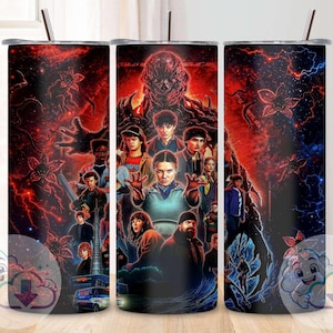 Puede incluir: Juego de tres vasos de acero inoxidable con un diseño de Stranger Things. El diseño presenta personajes y un monstruo sobre un fondo rojo y azul. Cada vaso tiene una tapa negra y una pajita. Adecuado para bebidas frías.