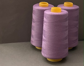 May include: Three spools of purple thread with yellow plastic tops.