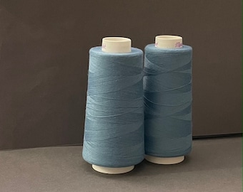 May include: Two spools of blue thread, each with a white label.