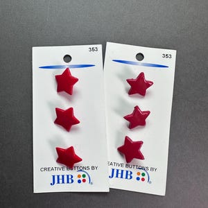 May include: Two cards of red star-shaped buttons. Each card has three buttons. The cards are white with the number 353 at the top. The text "CREATIVE BUTTONS BY JHB" is printed on the bottom of each card.