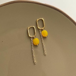 Może przedstawiać: Biały ceramiczny kubek z czarnym uchwytem i napisem "But First, Coffee" czarną, odręczną czcionką. Kubek stoi na białej powierzchni.