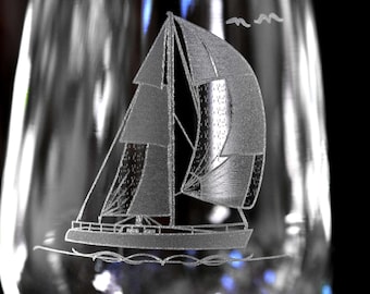 May include: A clear glass with an etched design of a sailboat with a single sail. The sailboat is in the center of the glass and is facing the right side of the image. The glass is partially filled with a clear liquid.