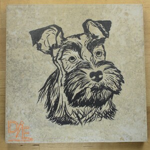 May include: A black and white illustration of a Schnauzer dog on a beige background. The dog is looking to the right and has a serious expression. The image is printed on a square tile with the text "D/E Design - Property - Engineering" in the bottom left corner.