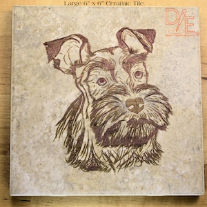 May include: A brown and white ceramic tile with a detailed illustration of a dog's head. The tile is 6 inches by 6 inches and has a rustic, textured surface. The dog's fur is depicted in shades of brown and black, and its eyes are brown. The tile is a part of a collection of ceramic tiles featuring different dog breeds.