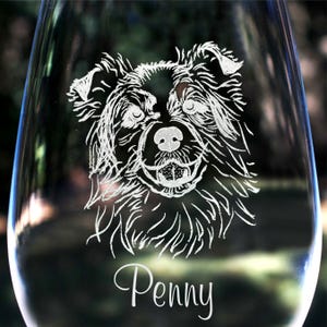 K&ouml;nnte beinhalten: Ein klares Weinglas aus Glas mit einem ge&auml;tzten Bild eines Hundekopfes. Der Hund hat schwarzes Fell und einen wei&szlig;en Fleck auf der Brust. Der Name des Hundes, "Penny", ist unter dem Bild einge&auml;tzt.