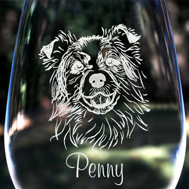 K&ouml;nnte beinhalten: Ein klares Weinglas aus Glas mit einem ge&auml;tzten Bild eines Hundekopfes. Der Hund hat schwarzes Fell und einen wei&szlig;en Fleck auf der Brust. Der Name des Hundes, "Penny", ist unter dem Bild einge&auml;tzt.