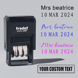 以下が含まれることがあります： 黒色のTrodat printy 4850スタンプ。テキスト「Mrs beatrice 10 MAR 2024」が黒、青、ピンクで表示されています。画像には「YOUR CUSTOM TEXT」のテキストも含まれています。