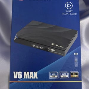 May include: A blue box with the text "V vSeeBox" and "V6 MAX" features a black smart media player. The box also displays "SMART MEDIA PLAYER", "4GB RAM", "64GB ROM", and "8K ULTRA HD".
