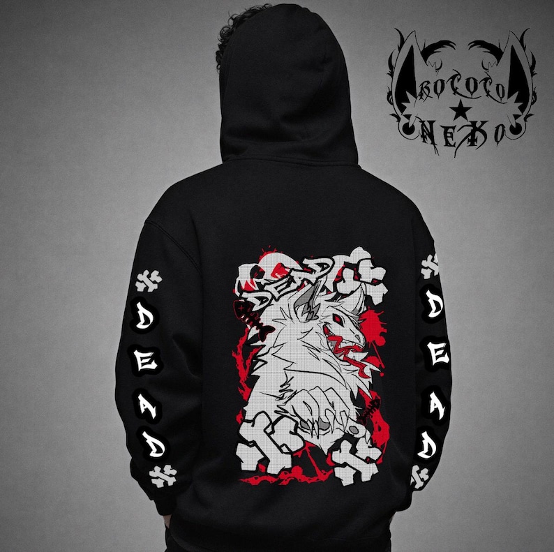 Puede incluir: Una sudadera negra con capucha que presenta un gr&aacute;fico en la espalda de una criatura blanca con detalles en rojo y la palabra DEAD. Las mangas muestran la palabra DEAD verticalmente con iconos de huesos. Un logo con el texto KOROTO NEXO aparece.