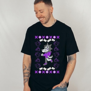 May include: Black t-shirt with a cartoon wolf character in a purple jacket and grey trousers. The design includes purple paw prints, XOXO symbols, and the text "RUFF". The shirt is a short-sleeved crew neck.