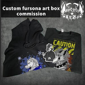 May include: A black hoodie and a black t-shirt featuring custom fursona art. The hoodie displays a white wolf character with blue paint splatters and snowflakes. The t-shirt features a yellow caution sign graphic with a wolf character.
