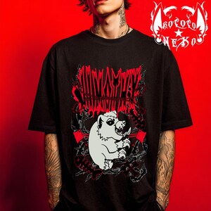 May include: A black short-sleeved t-shirt featuring a graphic print of a white creature with sharp teeth, surrounded by red text, barbed wire, and fish bone motifs. The top right corner displays a white logo with the text "KOKORO NEKO".