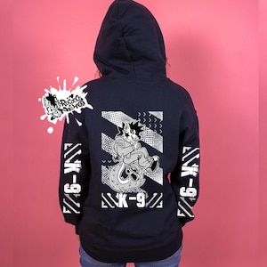May include: Dark navy hoodie featuring a cartoon wolf character design with the text "K-9" and geometric patterns in white. The sleeves also display the text "K-9".