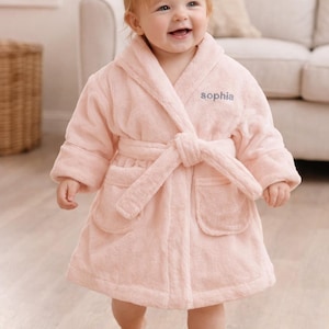 May include: A set of three ceramic mugs with a speckled, matte finish. The mugs are in shades of cream, light gray, and dark gray. Each mug has a simple, minimalist design and a rounded handle.