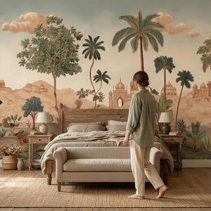 May include: A bedroom with a large mural depicting a desert landscape with palm trees and buildings. A wooden bed, a bench, and two nightstands with lamps are in front of the mural. A person is walking in the room.