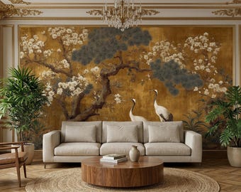 Könnte beinhalten: Ein Wohnzimmer mit beigem Sofa, rundem Holztisch und goldfarbenem Wandbild mit einem Baum mit weißen Blüten und zwei Kranichen. Grüne Pflanzen in Töpfen flankieren das Sofa.