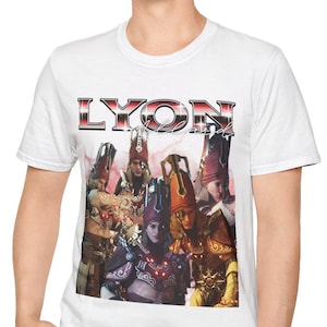 May include: White t-shirt with a graphic of a group of people in elaborate costumes, and the word "LYON" in a metallic font. The image is centered on the shirt.