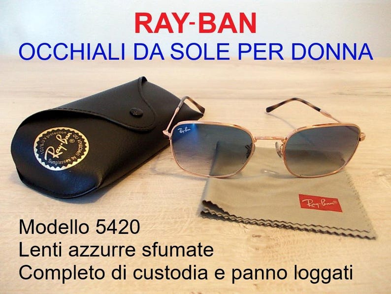 Pu&ograve; includere: Occhiali da sole Ray-Ban, modello 5420, con lenti sfumate blu. Gli occhiali hanno una montatura color oro e sono accompagnati da un astuccio nero e un panno per la pulizia. Il logo Ray-Ban &egrave; visibile sull'astuccio e sul panno.