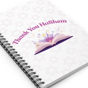 Può includere: Quaderno a spirale bianco con la scritta "Thank You HaShem" in viola. La copertina presenta un'illustrazione di un libro aperto con stelle e uno sfondo lilla chiaro con motivi a stella di David.
