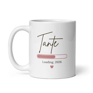 Könnte beinhalten: Weiße Keramiktasse mit dem Wort "Tante" in Schreibschrift. Darunter befindet sich ein Ladebalken und der Text "Loading. 2026" mit einem kleinen Herzsymbol. Die Tasse hat einen gebogenen Henkel.