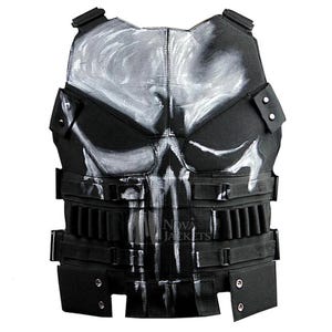 May include: A black tactical vest featuring a large, white, hand-painted skull graphic across the chest. The vest includes adjustable side straps, multiple horizontal webbing loops, and metallic silver snap buttons on the lower front panels.