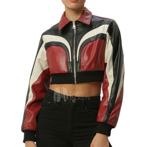 May include: A cropped jacket featuring a color-blocked design in black, red, and white. The jacket has a pointed collar, a full-length silver-tone front zipper, and black ribbed cuffs and hem. The text NOVA JACKETS is visible on the lower front.