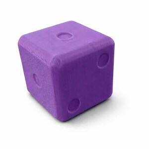 May include: A solid purple die with rounded edges and indented circular markings. The die has three visible sides, each with a different number of indentations, representing the numbers one, two, and three. The die is a cube shape.