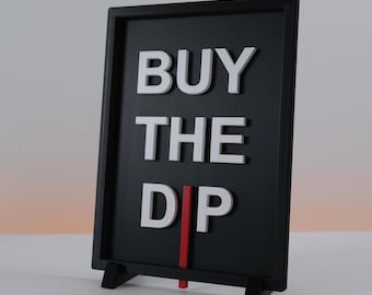 May include: A black sign with white lettering that reads "BUY THE DIP." The sign has a red vertical line and is propped up by two black legs. The background is a gradient of white and orange.
