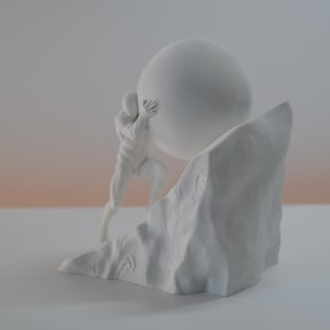 May include: A matte white sculpture depicting a stylized human figure pushing a large sphere up a jagged, rocky incline. The monochromatic piece features smooth surfaces on the figure and sphere, contrasting with the textured, uneven rock base.