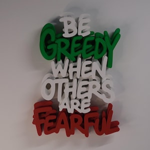 Könnte beinhalten: Ein dreidimensionales Wandschild mit dem Text BE GREEDY WHEN OTHERS ARE FEARFUL. Das Wort GREEDY ist grün, die Wörter BE, WHEN, OTHERS, ARE sind weiß und das Wort FEARFUL ist rot, alles in einem geschichteten, gestapelten Design.