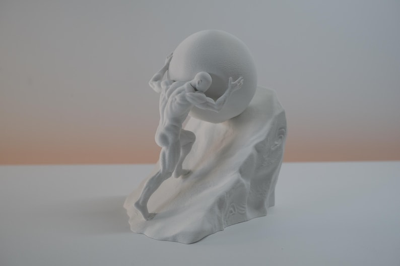 May include: A matte white sculpture depicting a muscular figure pushing a large sphere up a rocky incline. The figure is shown in a dynamic pose with defined musculature, leaning into the weight of the round object while ascending the textured base.