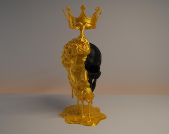 May include: A dual-toned sculpture featuring a gold-colored classical bust on the left side and a black skull on the right side. A gold crown sits atop the head, with gold liquid-like drips extending down to a puddle at the base of the object.