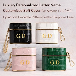 May include: Four personalized AirPod cases in black, white, pink, and green, each with a gold chain and the initials "G.D." The cases have a crocodile pattern and gold trim, with the text "Luxury Personalized Letter Name" at the top.