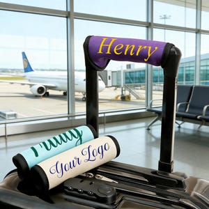 Puede incluir: Maleta negra con un asa que presenta una envoltura morada con "Henry" en escritura amarilla. Envolturas de asa adicionales en azul claro y crema con texto personalizado. Fondo de aeropuerto con avión.