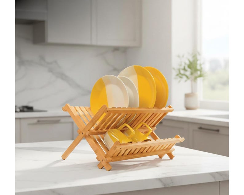 Puede incluir: Un escurreplatos de madera clara con platos amarillos y blancos y tazas amarillas. El escurreplatos est&aacute; colocado sobre una encimera blanca. El fondo muestra una cocina con armarios blancos y una ventana.