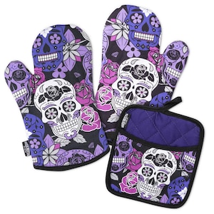 Puede incluir: Dos guantes de cocina y un agarrador cuadrado con fondo negro y un patrón repetitivo de calaveras de azúcar moradas y blancas, rosas rosas y moradas, y pequeños diamantes. Cada artículo tiene un borde negro y una pequeña etiqueta negra.