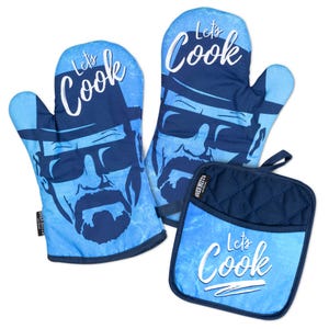 May include: A set of two light blue oven mitts and one square pot holder featuring a dark blue graphic of a man wearing a hat and sunglasses. The text "Let's Cook" is printed in white script on each item. The pot holder has a quilted texture.