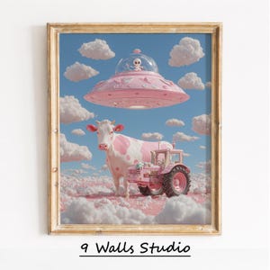 May include: A framed art print depicting a pink cow, tractor, and a UFO with an alien against a blue sky with clouds. The cow has pink markings, and the tractor is pink. The text "9 Walls Studio" is at the bottom of the print.