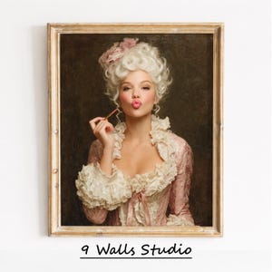 May include: A framed portrait of a woman in a pink and white Rococo-style dress and wig, holding a makeup brush to her lips. The artwork has a gold-colored frame and the text "9 Walls Studio" at the bottom.