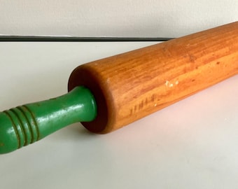 Rodillo de madera vintage con mangos pintados de verde.