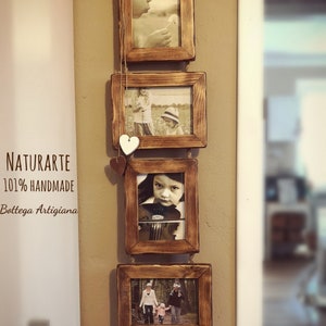 Op de afbeelding: Een set van vier rustieke houten fotolijsten die aan een muur hangen. De lijsten zijn met touw verbonden en bevatten foto's van kinderen. De lijsten zijn donkerbruin gebeitst en hebben een verweerde uitstraling. De tekst "NATURARTE 101% HANDMADE Bottega Artigiana" is zichtbaar op de muur.