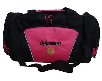 Peut inclure: Sac de sport noir et rose avec un ballon de basket et le mot "dybainee" brodé sur le devant.