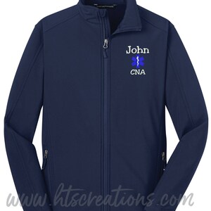 May include: Navy blue soft-shell jacket with a zipper closure. The jacket has a white embroidered star of life with a caduceus and the text "John CNA".