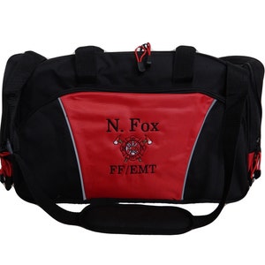 Könnte beinhalten: Schwarz-rote Sporttasche mit Schultergurt. Die Tasche hat ein rotes Feld mit dem Namen "N. Fox" und dem Text "FF/EMT", der unter einem Feuerwehr-Emblem gestickt ist. Sie hat einen schwarzen Griff und einen schwarzen Schultergurt.