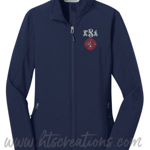 Könnte beinhalten: Marineblaue Softshelljacke mit Reißverschluss und zwei Reißverschlusstaschen. Die Jacke hat ein weiß gesticktes Monogramm "KSA" und ein rotes Feuerwehr-Emblem.